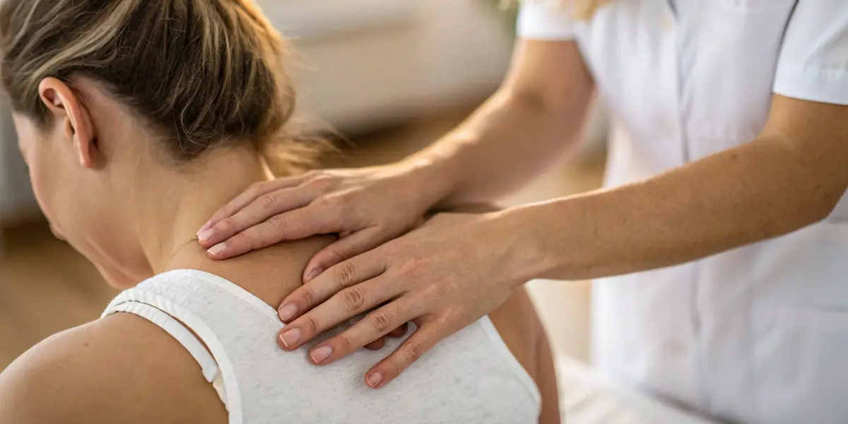Patiënt op een behandeltafel terwijl een zorgverlener een sessie uitvoert in professionele kinesitherapie, osteopathie, causopractie, podologie en NEI-therapie bij praktijk M-Core.